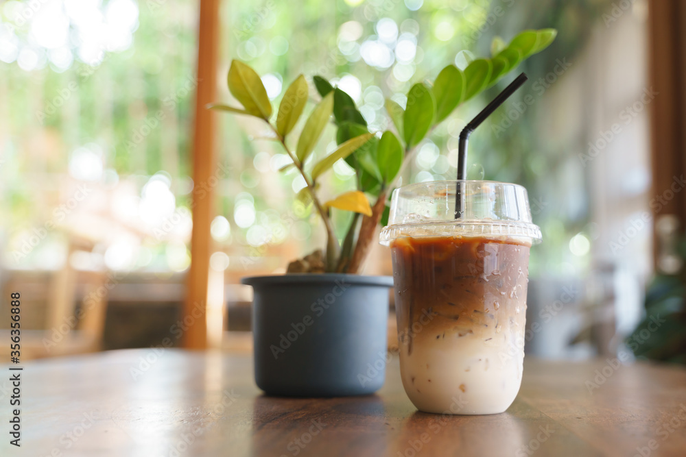 Cup of iced milk coffee with plastic straw