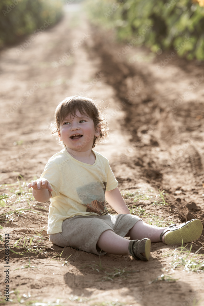Infant boy sitting on a ground and playing. Infant boy sitting on a ground and playing.