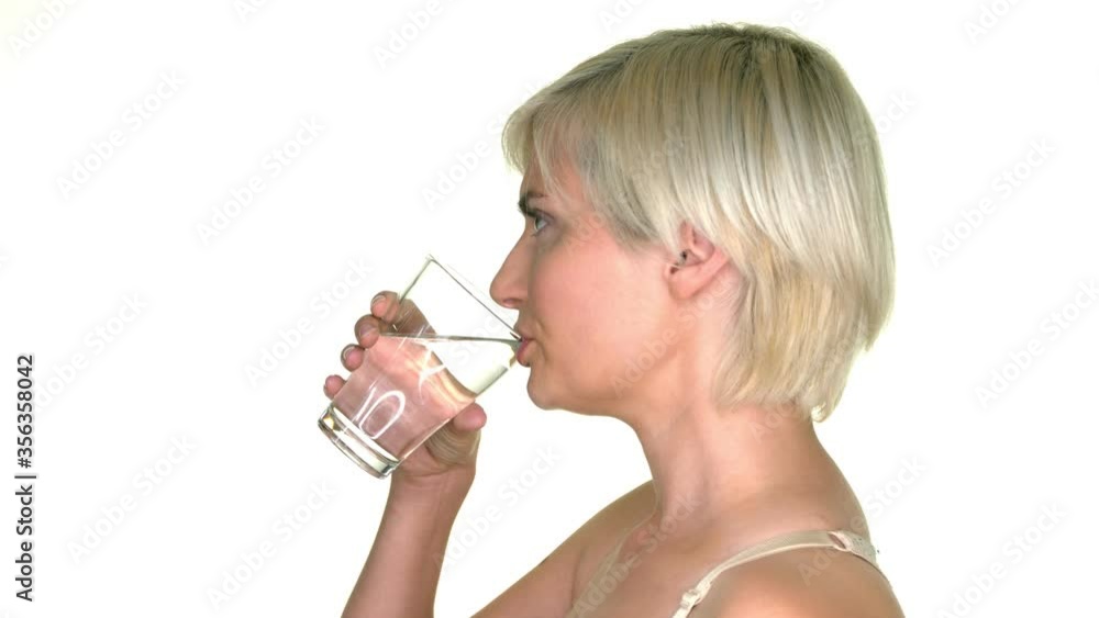 Side view of woman drinking water, standing on white background. She is thirsty. Pure fresh mineral water to refreshing body in heat. Side view of woman drinking water, standing on white background. She is thirsty. Pure fresh mineral water to refreshing body in heat.