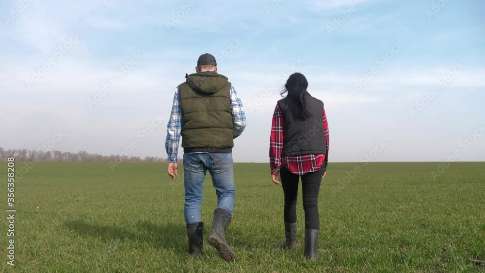 happy family of farmers teamwork a red neck works go on the green field. man and girl farmer are studying eco farming farming harvesting concept. woman lifestyle and worker go walking on agricultural happy family of farmers teamwork a red neck works go on the green field. man and girl farmer are studying eco farming farming harvesting concept. woman lifestyle and worker go walking on agricultural