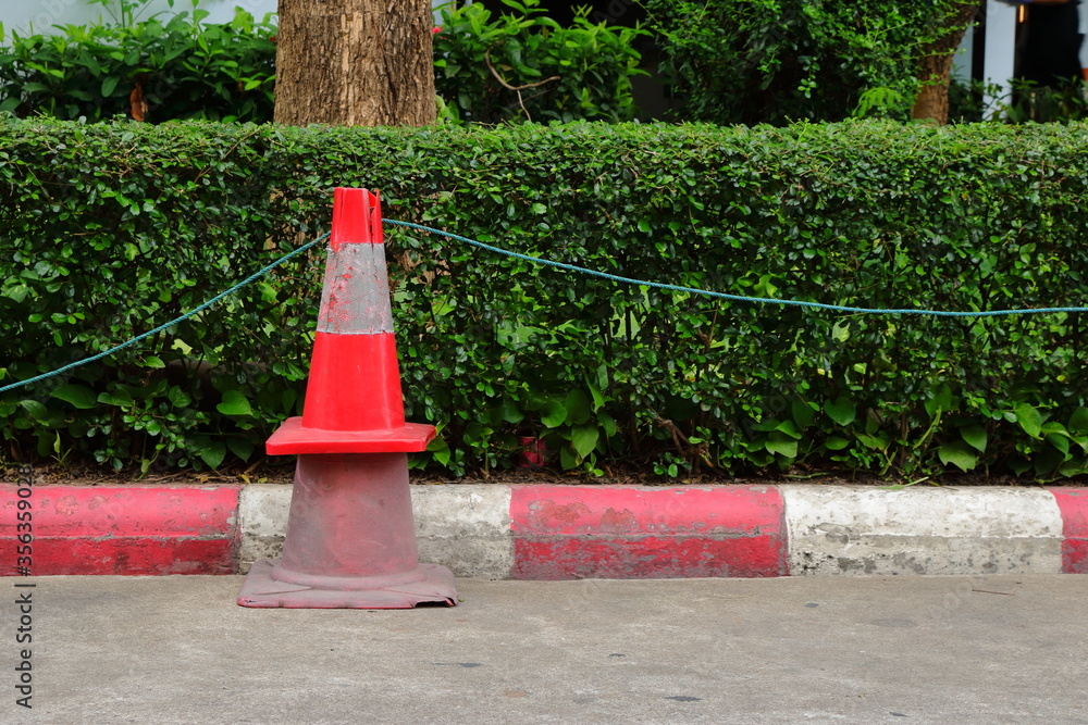 Closeup stack of two traffic cones, the smaller one with brighter color is above the larger with faded color, together we are strong concept Closeup stack of two traffic cones, the smaller one with brighter color is above the larger with faded color, together we are strong concept