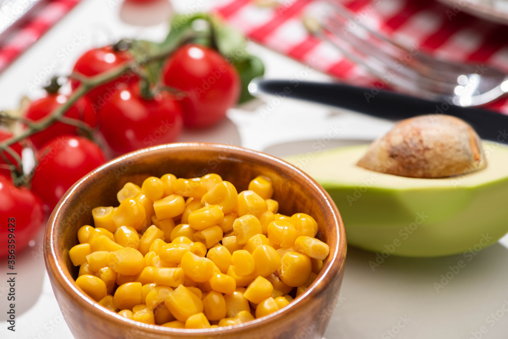 selective focus of fresh avocado, corn and cherry tomatoes selective focus of fresh avocado, corn and cherry tomatoes