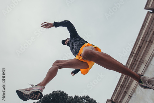 ragazzo atletico si allena saltando in aria con forza e determinazione durante una sessione solitaria di allenamento in città 