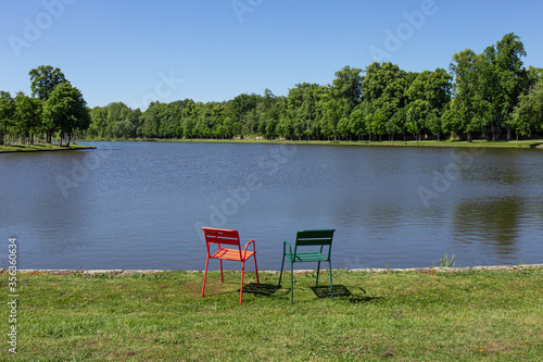 Deux chaises métalliques au bord d'un lac