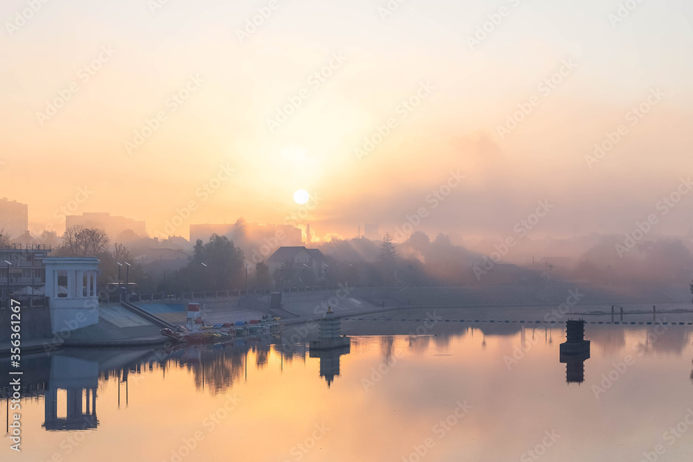 Light on the embankment of the river in the fog, beautiful nature, display in the water