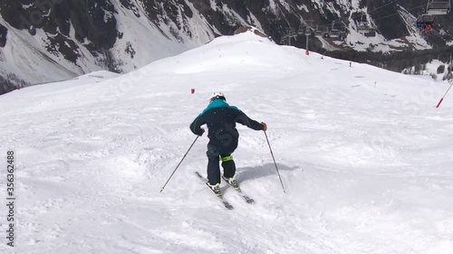 Skiing mogules fast and in control on a steep ski slope. Bumbs skiing with great ski technique. photo