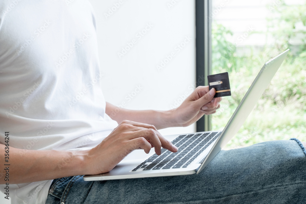 Young man people who hold credit cards and use laptops for online shopping and making payments Internet Young man people who hold credit cards and use laptops for online shopping and making payments Internet