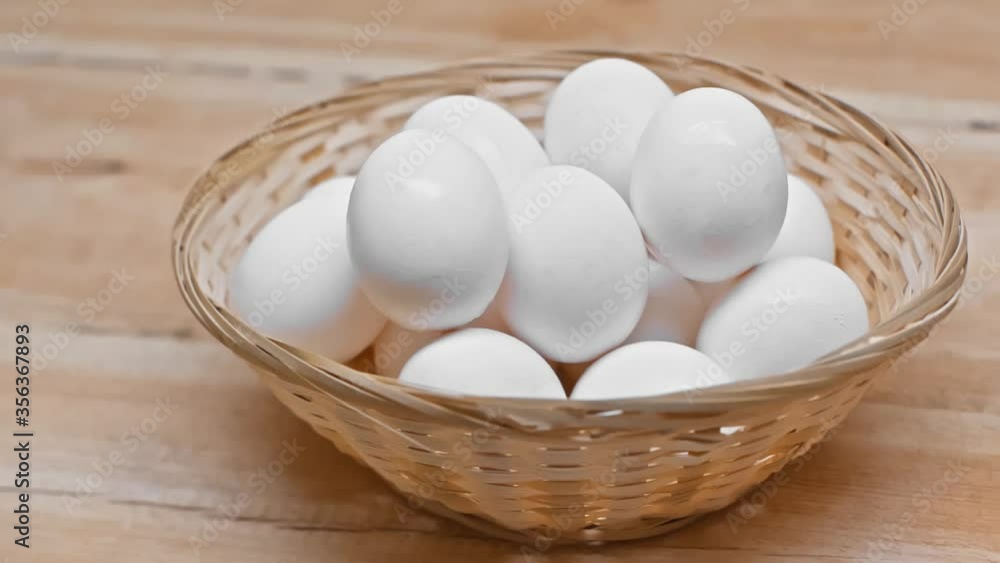 Eggs in wicker basket and jug of milk on wooden surface Eggs in wicker basket and jug of milk on wooden surface