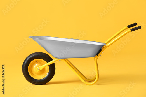 Empty wheelbarrow on color background Fototapet