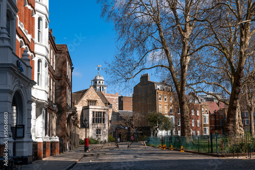 City of London, UK - 03/24/2019 : Tourists come across many small squares like Charterhouse Square while walking in the city surrounded by beautiful old buildings