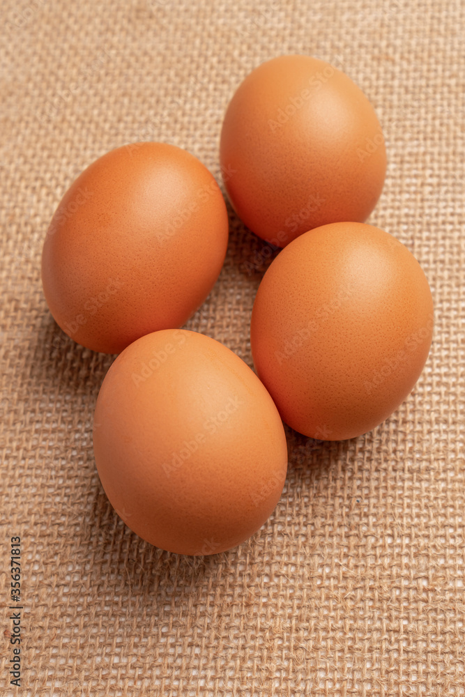 Four chicken eggs on sackcloth close-up. Front view Four chicken eggs on sackcloth close-up. Front view