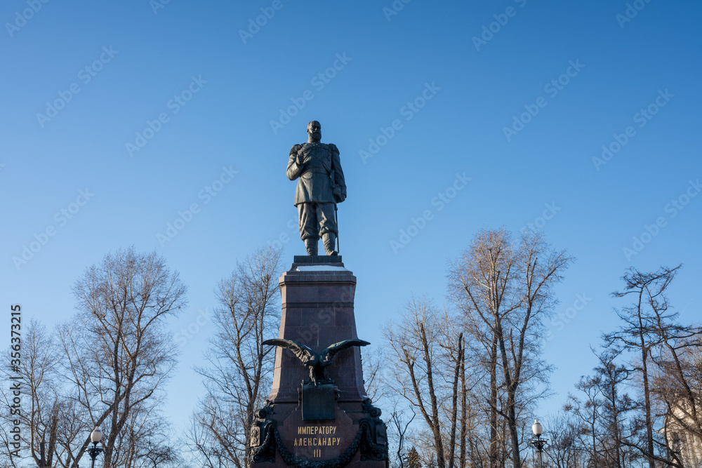 Fototapeta premium Statue of Cossack pioneer Yakov Pokhabov, the founder of Irkutsk located in front of Epiphany Cathedral an iconic landmark of this city.