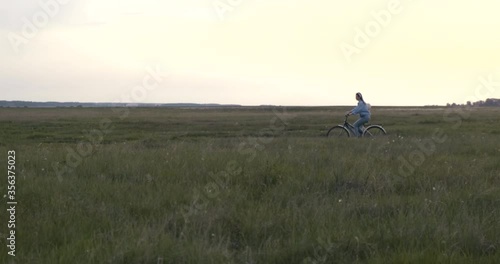 Wallpaper Mural Boundless Village Field at Sunset. Girl Rides Country Road on Bicycle. Clear sky. Sun has already set. Low Green Grass. Summer. Village. Walk on bike. Slow motion. Vault. Ecology. Fresh air. Meadow Torontodigital.ca