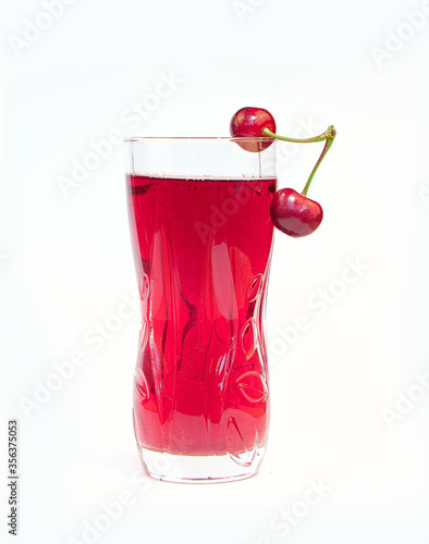 glass cherry juice and ripe and juicy cherry with green leaves on white background