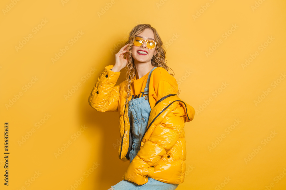 Happy model woman in yellow winter jacket on bright background Happy model woman in yellow winter jacket on bright background