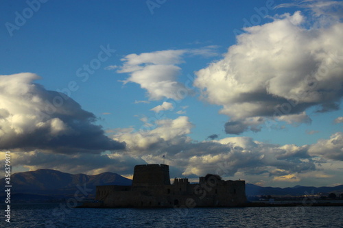 The fortress of Bourtzi at Naflion Bay, with a background of clouds photo