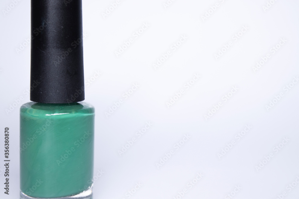 Obraz premium A bottle with blue nail polish on white background. nail lacquer. Nail manicure concept. Isolated, copy space. 