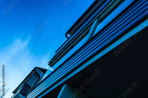 a blue house shot diagonally against the sky