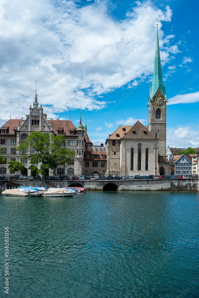 Zurich city downtown riverside cityscape with covered docked boats and old church towers summer day with clouds