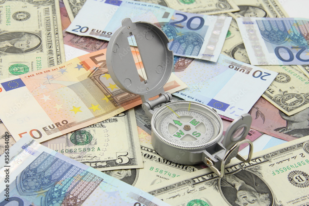Small compass on international paper money. Where to move? Direction in economy to be found. Small compass on international paper money. Where to move? Direction in economy to be found.