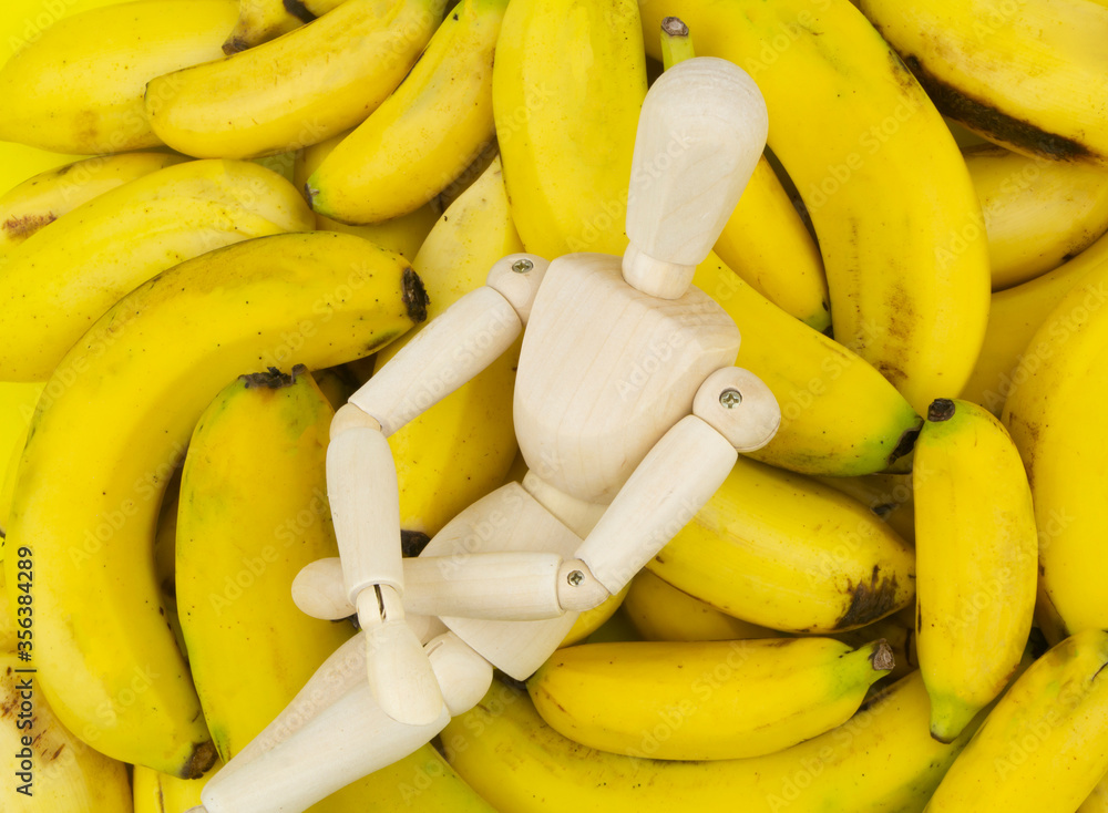 Wooden figurine on banana background