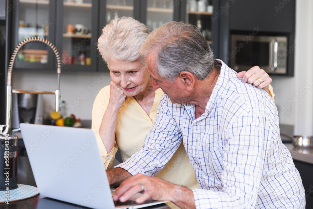 Caucasian senior couple using laptop at home Caucasian senior couple using laptop at home