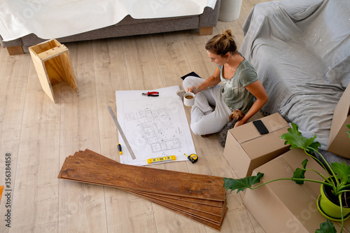 Women in Social Distancing sitting on the floor examining a plan