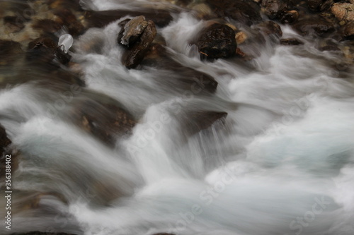 Milky like water and rocks in winter cold river.