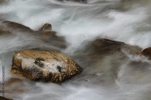 Stream, rocks and water in autumn forest.