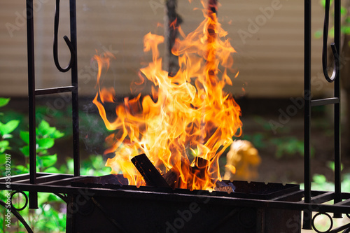 Barbecue on nature. Picnic preparation. Firewood on the grill outdoors.