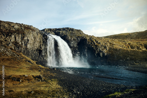 Wild waterfall in Iceland. Waterfall in the light of the setting sun  wild nature. nobody around.