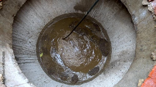 Plumber cleans clogged pipes in outside. The plumber cleans the pipes with equipment.