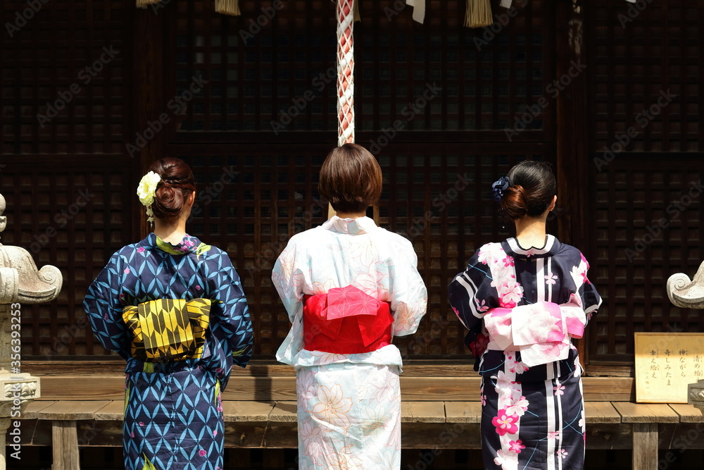日本の神社でお参りする美しい浴衣の女性