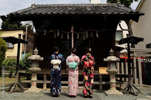 日本の神社でお参りする美しい浴衣の女性