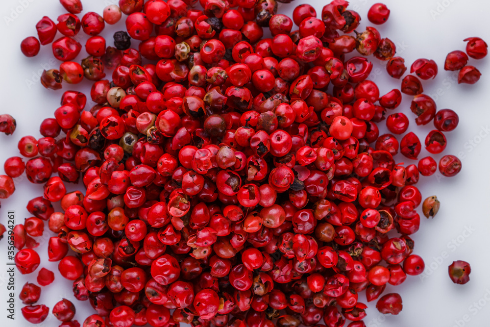 fragrant pink peppercorns on white acrylic background fragrant pink peppercorns on white acrylic background