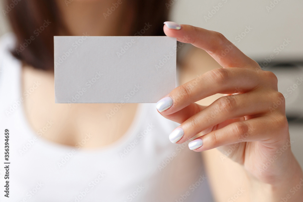 Obraz premium Man holding a white business card in his hand, close up
