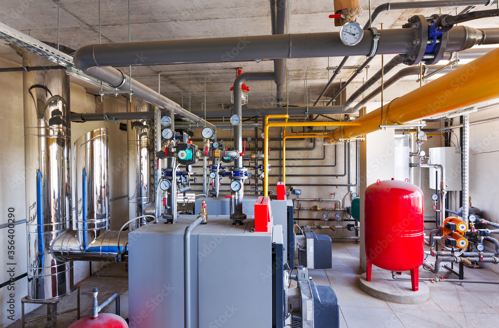 interior of a modern gas boiler room, with a water treatment system, many valves and sensors