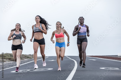 Muscular diverse women running on road