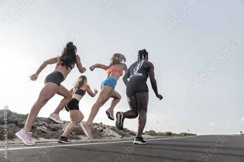 Diverse female friends running in evening together