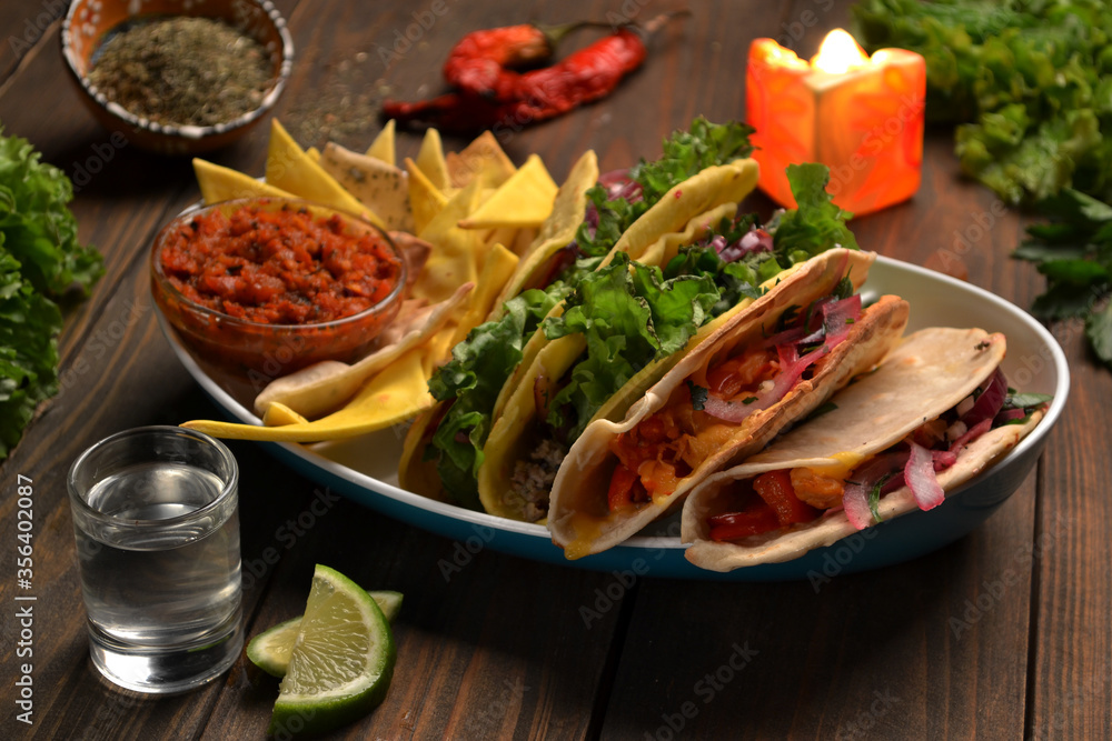 Mexican tacos with chicken, beef, paprika, lettuce, tomatoes and nachos, lime juice, tequila.