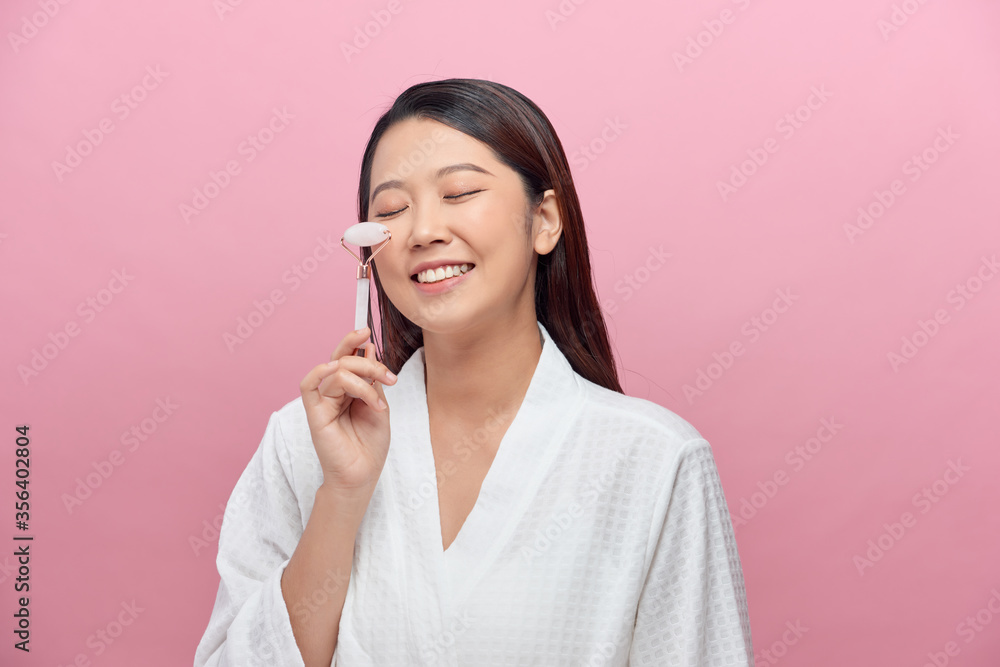 Beautiful woman holding jade facial roller Beautiful woman holding jade facial roller