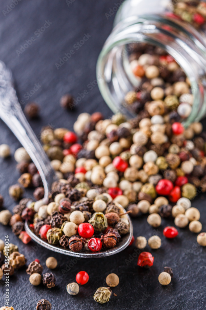 mix of peppercorns on a dark stone background mix of peppercorns on a dark stone background