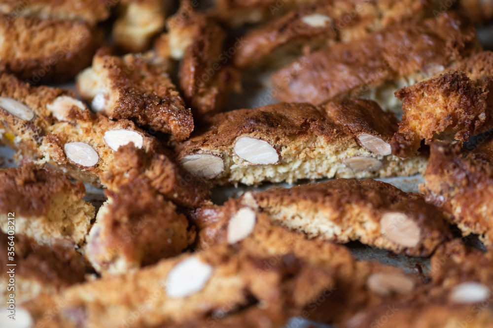Fresh baked Italian cantucci with almonds on a baking tray. Tuscan Biscotti. Traditional cantuccini. Homemade Italian sweets biscuits (cookies) Fresh baked Italian cantucci with almonds on a baking tray. Tuscan Biscotti. Traditional cantuccini. Homemade Italian sweets biscuits (cookies)