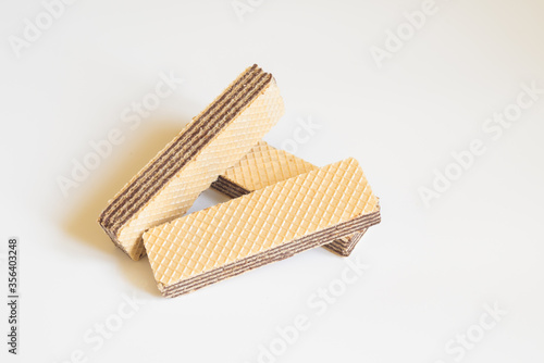 Crispy chocolate wafers. Waffles sticks on the light background. Tasty waffles with space for text. Sweet food