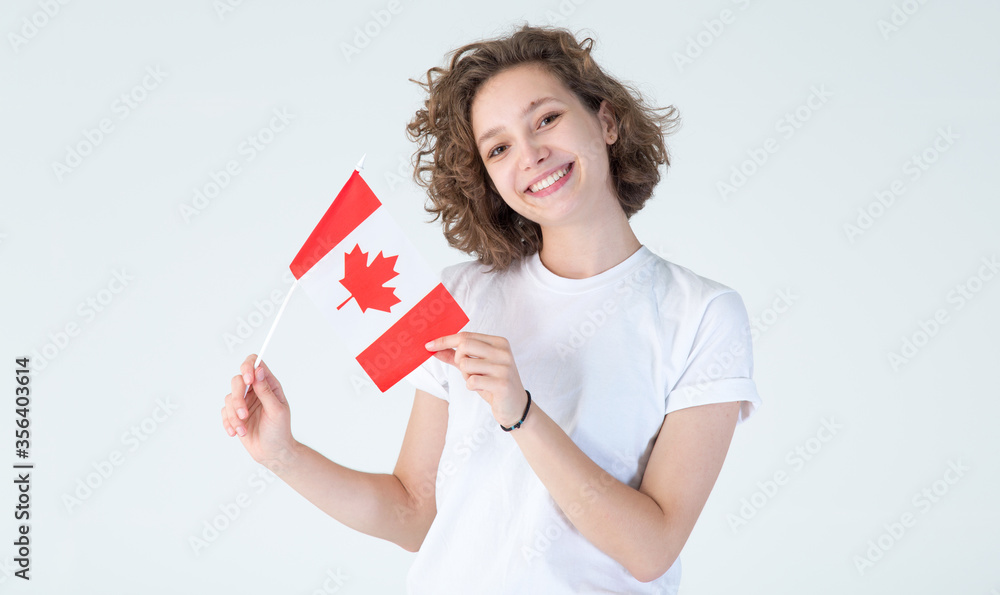 Portrait young girl student with the flag of Canada in hands. Beautiful Canadian woman. Portrait young girl student with the flag of Canada in hands. Beautiful Canadian woman.