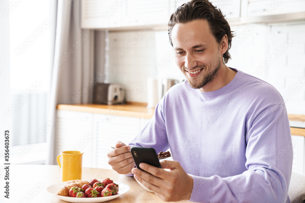 Attractive young man sitting at the kitchen table Attractive young man sitting at the kitchen table