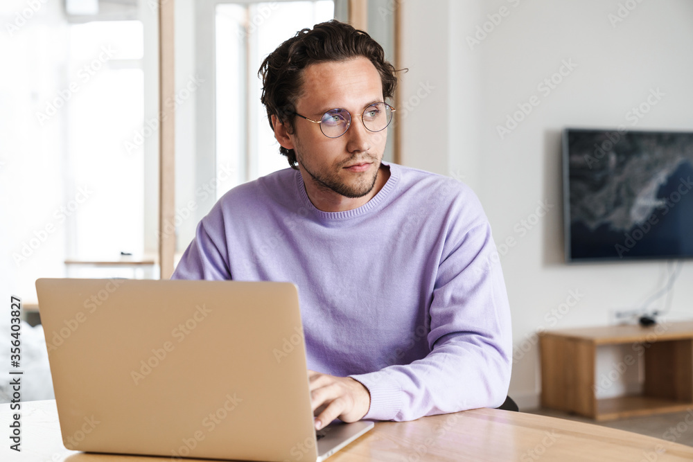 Attractive young man sitting at the kitchen table Attractive young man sitting at the kitchen table