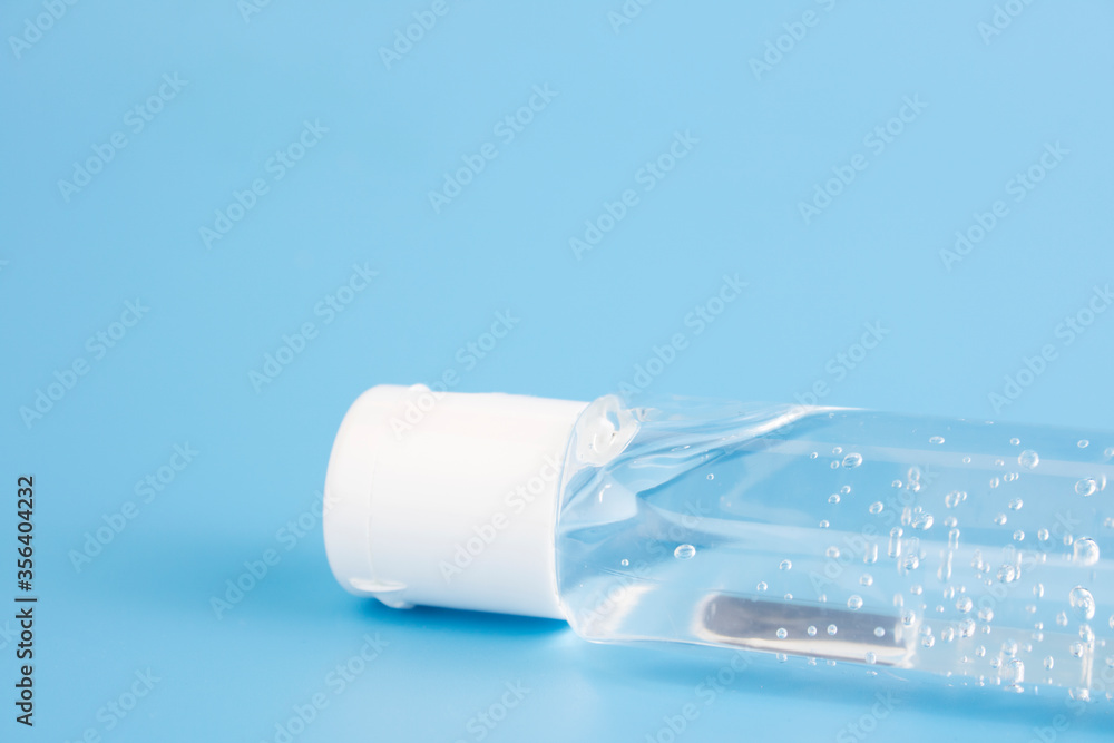 Bottle of instant antiseptic hand sanitizer transparent gel isolated on blue background, no label. Antibacterial, hydro alcoholic gel, ethyl alcohol. Mini travel pocket small size. Copy space Bottle of instant antiseptic hand sanitizer transparent gel isolated on blue background, no label. Antibacterial, hydro alcoholic gel, ethyl alcohol. Mini travel pocket small size. Copy space