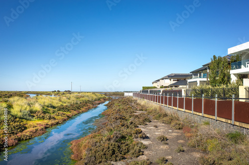Wetlands and a row of residential houses.Skeleton Creek at Sanctuary Lakes, Melbourne, VIC Australia. © Doublelee