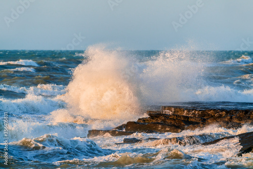 Big waves crash against coastal cliffs. Sea storm